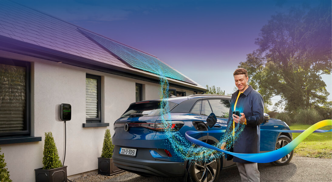 Man standing near his car charging at home.